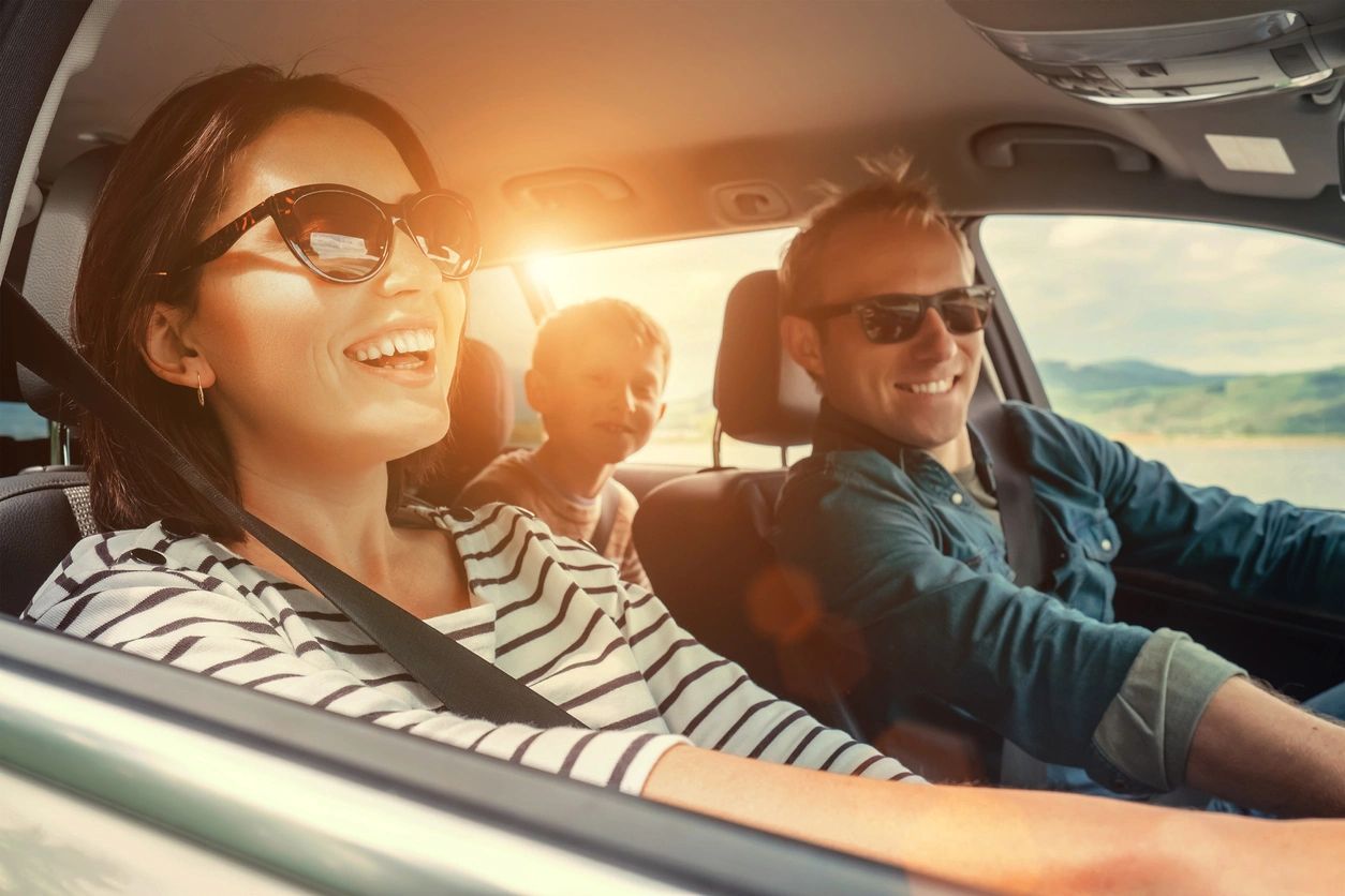 A group of people riding in the back seat of a car.